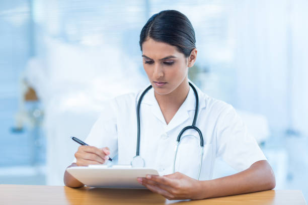 istock Beautiful doctor holding clipboard with file 691263634