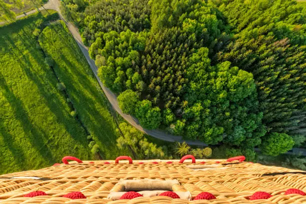 View from basket in hot air balloon, flying above rural countryside. Air travel and transportation, beautiful nature landscape shot from aerial perspective