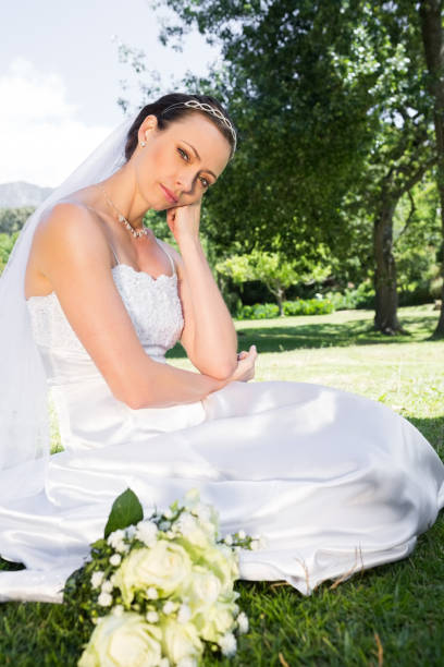 istock Sad bride with hand on chin in garden 691276010