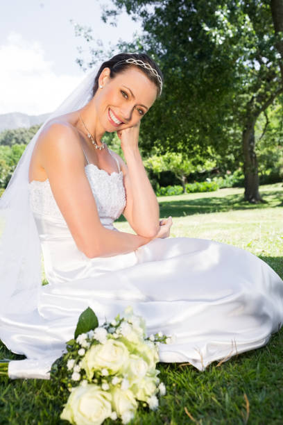istock Happy bride sitting on grass in garden 691276036