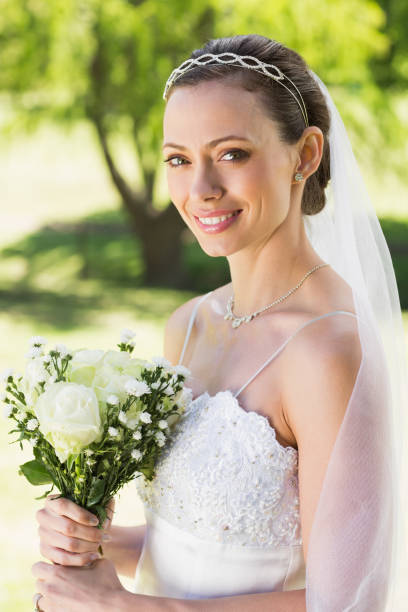 istock Young bride holding bouquet in garden 691276304