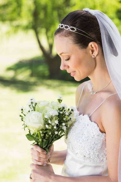 istock Shy bride holding bouquet in garden 691276330