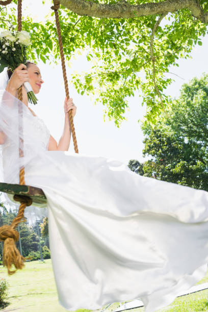 istock Thoughtful bride swinging in garden 691276348