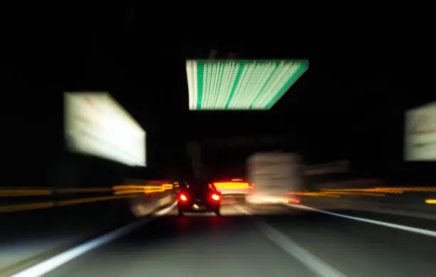 Traffic signs light stripes thru night highway journey