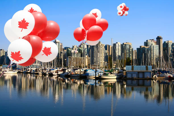 Vancouver Canada day balloons Canada day maple leaf balloons floating over Vancouver's Coal Harbor. 150th anniversary stock pictures, royalty-free photos & images