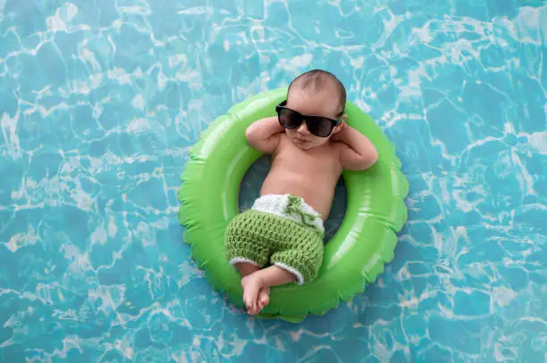 Photo of Newborn Baby Boy Floating on a Swim Ring