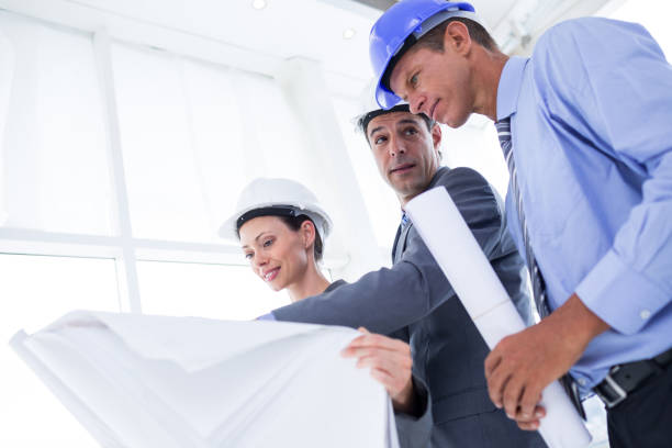 istock Businessman explaining a blueprint to his colleagues 691308696