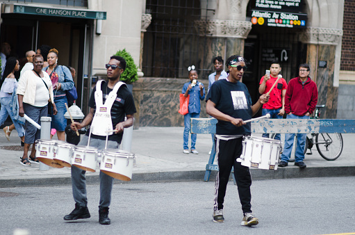 New York City - May 28, 2017: Two young men play drums on the street at the outdoor bazaar of DanceAfrica, the annual festival celebrating African and African-American dance, music, and culture sponsored by BAM, the Brooklyn Academy of Music.
