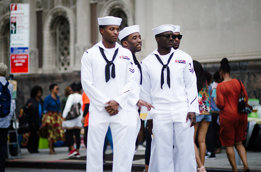 New York City - May 28, 2017: Four handsome young sailors in town for Fleet Week pose for admirers on the street at the outdoor bazaar of DanceAfrica, the annual festival celebrating African and African-American dance, music, and culture sponsored by BAM, the Brooklyn Academy of Music.
