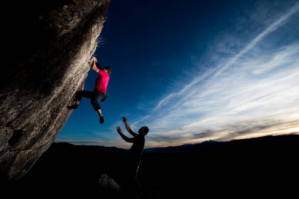 istock Brave climber attempting hard move with friend spotting 691315874