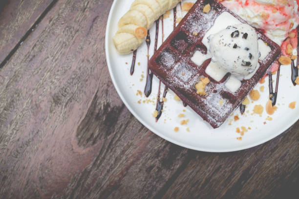 chocolate waffles with vanilla ice cream, banana, whipped cream and strawberry syrup