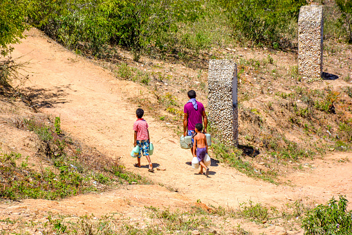 arcoverde, Pernambuco, Brazil- April 21, 2015:Man and children carrying water in Arcoverde city in northeast of Brazil.