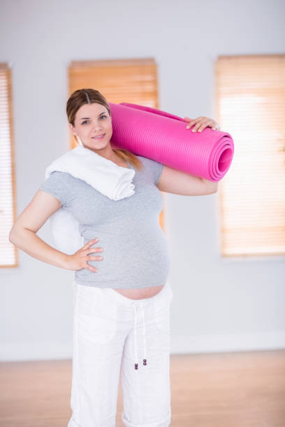 istock Pregnant woman holding exercise mat 691325702