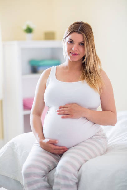 istock Pregnant woman holding her bump 691325798