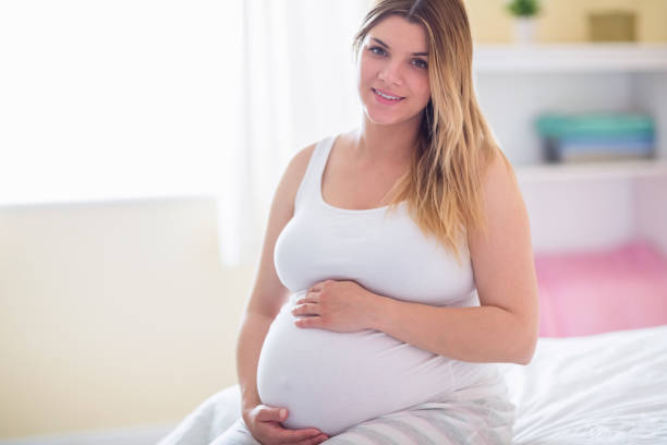 istock Pregnant woman holding her bump 691325850