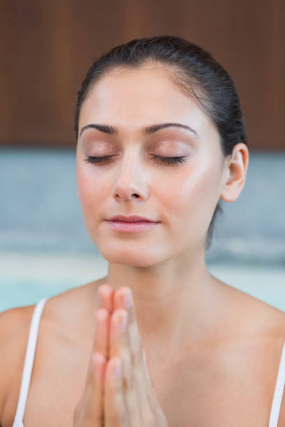 istock Peaceful woman in white sitting with hands together 691326594