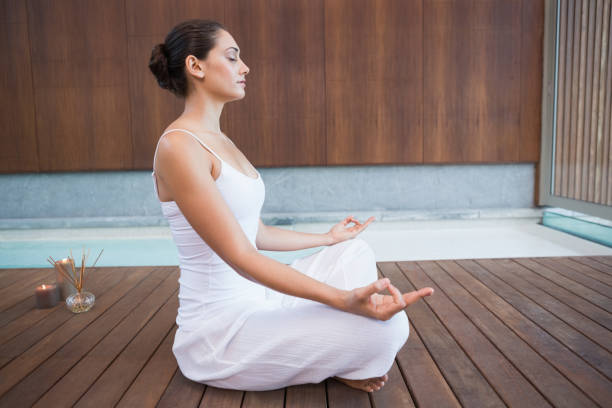 istock Peaceful brunette in white sitting in lotus pose 691326822