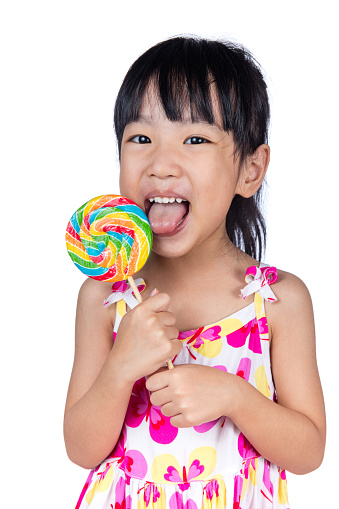 Asian Little Chinese girl eating lollipop in isolated white background