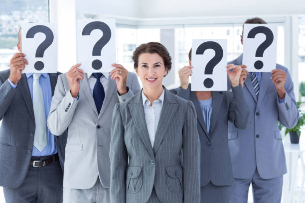 istock Business colleagues hiding their face with question mark sign 691330640