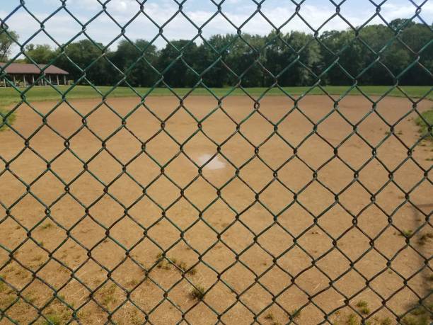 istock muddy baseball field and fence 691330712