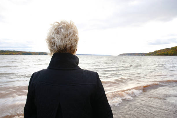 Rear view of woman overlooking river in Autumn.