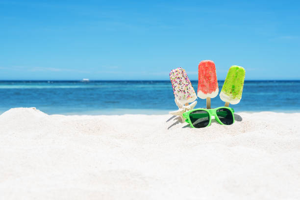 istock Ice cream popsicles and sunglasses on the white sandy beach 691341186