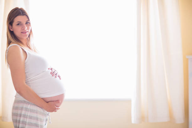 istock Pregnant woman holding her bump 691344088