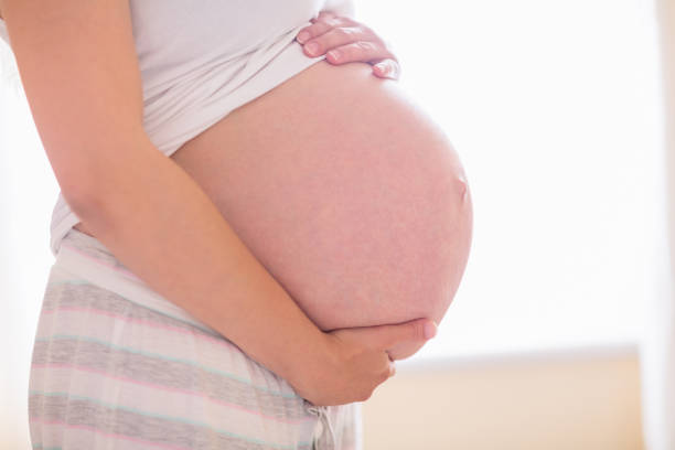 istock Pregnant woman holding her bump 691344096
