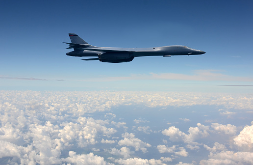 Strategic nuclear bomber in flight above clouds