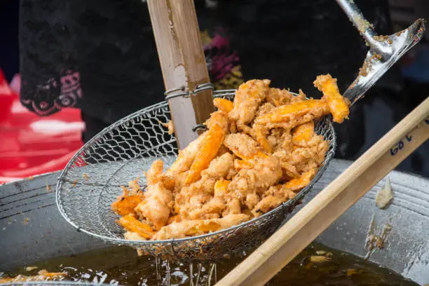 Photo of Sweetened fried banana fritters in hot oil, Thailand dessert