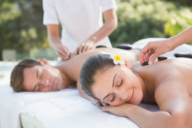 istock Attractive couple enjoying hot stone massage poolside 691367026