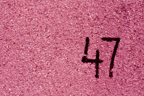 istock number fourty seven on pink plaster wall. 691370796