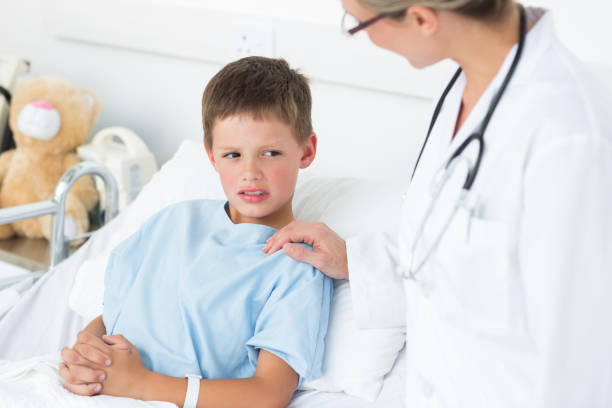 istock Doctor comforting sick boy in ward 691370988