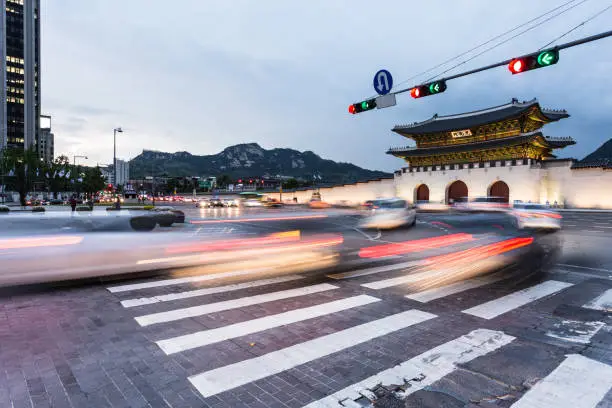 Traffic rushing at night in front of the Gwanghawmun gate in front of the Gyeongbokgung palace in the heart of historic Seoul, South Korea capital city.