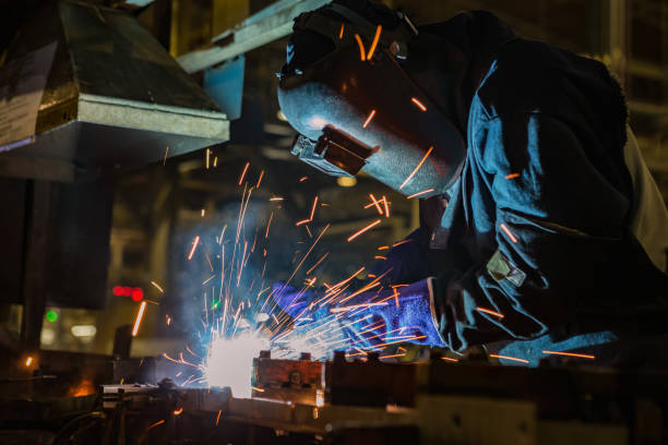 istock Industrial worker is welding assembly part in car factory 691373836