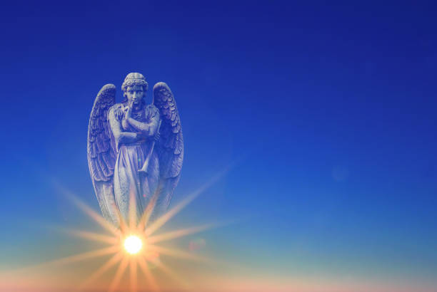 istock Angel over blue sky with rays of sun light 691374718