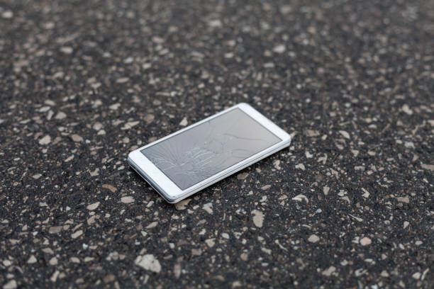 istock Phone with broken screen lying on the street 691377030