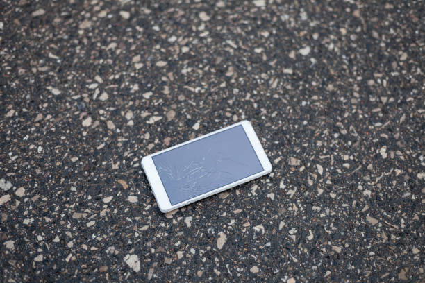 istock Phone with broken screen lying on the street 691377032