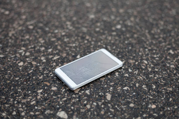 istock Phone with broken screen lying on the street 691377058