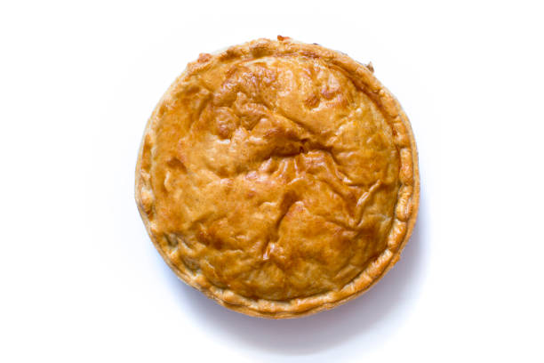 Overhead shot of a cooked whole meat pie over a white background