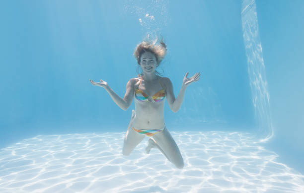 istock Cute blonde smiling at camera underwater in the swimming pool 691388020