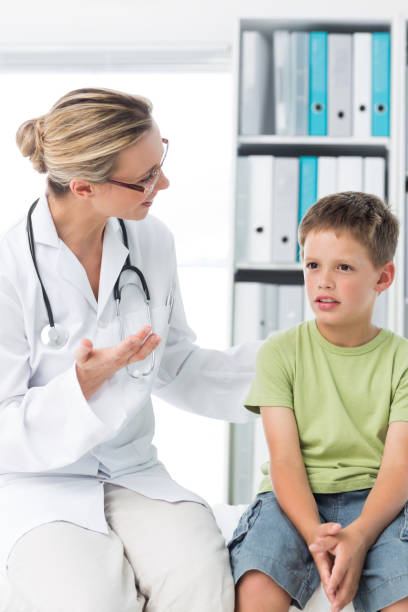 istock Doctor talking with boy in clinic 691388022