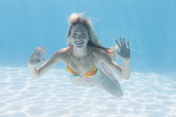 istock Cute blonde smiling at camera underwater in the swimming pool 691388030