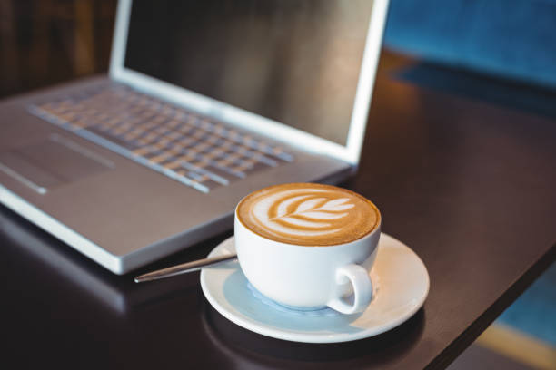 istock Close-up of laptop and coffee on table 691392820