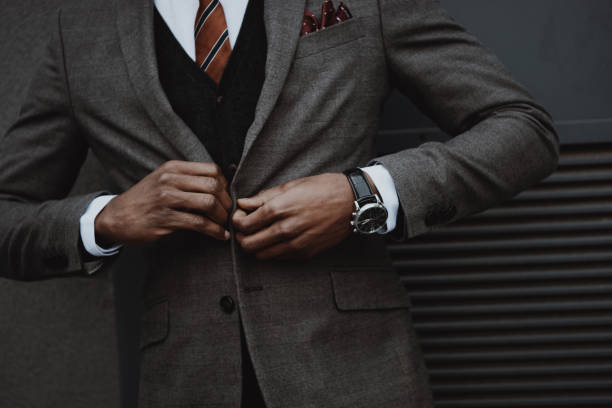 confident stylish businessman wearing suit outdoors at wall