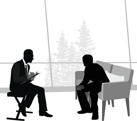 A vector silhouette illustration of a therapist discussing issues with a patient.  The Doctor sits and writes on a clipboard while the patient is hunched over on a sofa.  Outside of large windows there are trees.