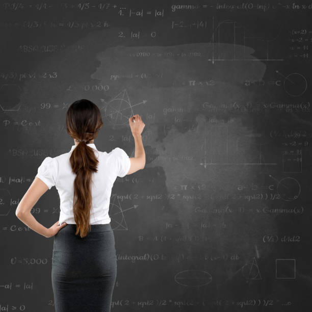 istock Businesswoman writing on blackboard mathematical equation 691414312