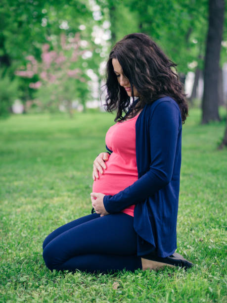 istock Pregnant womant looking at belly 691414590