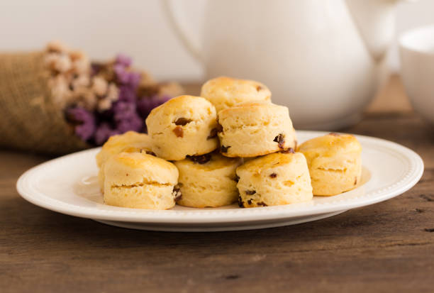 bolinhos de passas caseiras servem com geleia de morangos caseira, creme de leite e chá. scones é bolo inglês para chá da tarde chá, creme. condado de devon deliciosos scones ou estilo de creme da cornualha. - cornish cream tea - fotografias e filmes do acervo