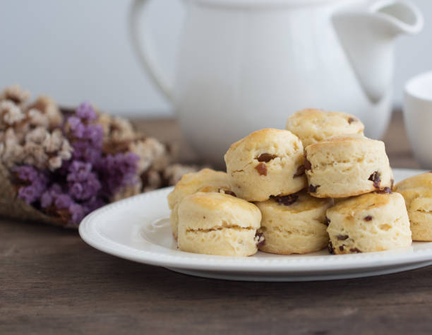 le focaccine di uvetta fatte in casa servono con marmellata di fragole fatta in casa, panna coagulata e tè. scones è una pasticceria inglese per tè pomeridiano, tè alla crema. deliziose focaccine devon shire o crema della cornovaglia. - cornish cream tea foto e immagini stock